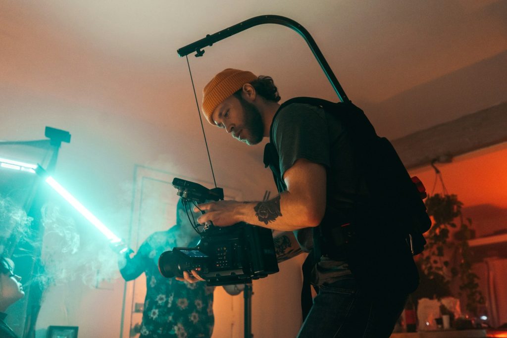 man in black t-shirt holding black video camera