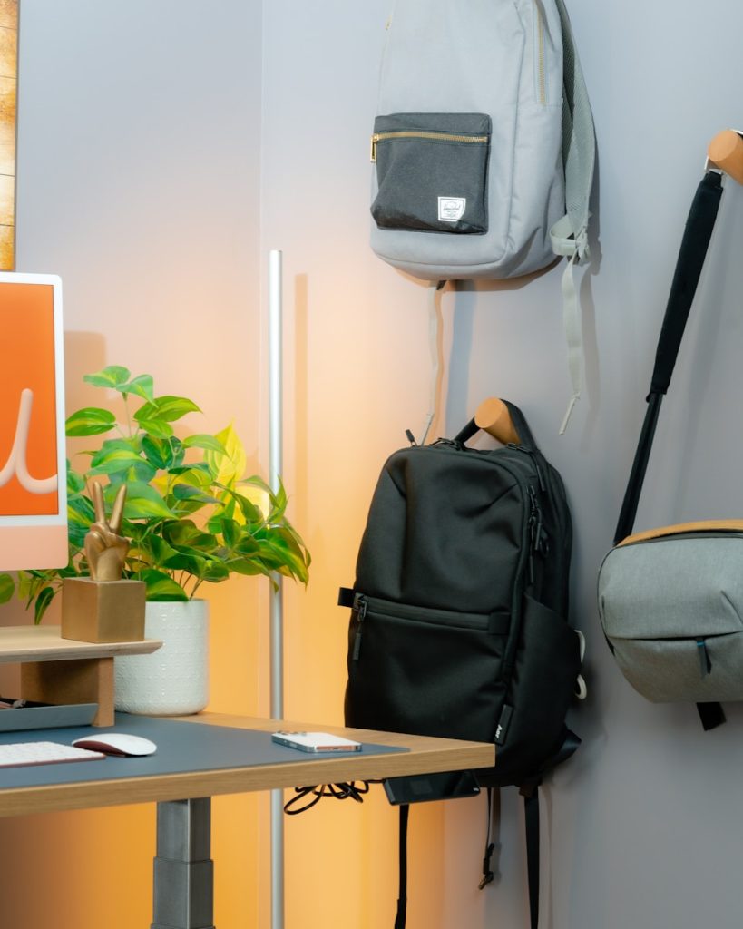 a backpack hanging on a wall next to a computer